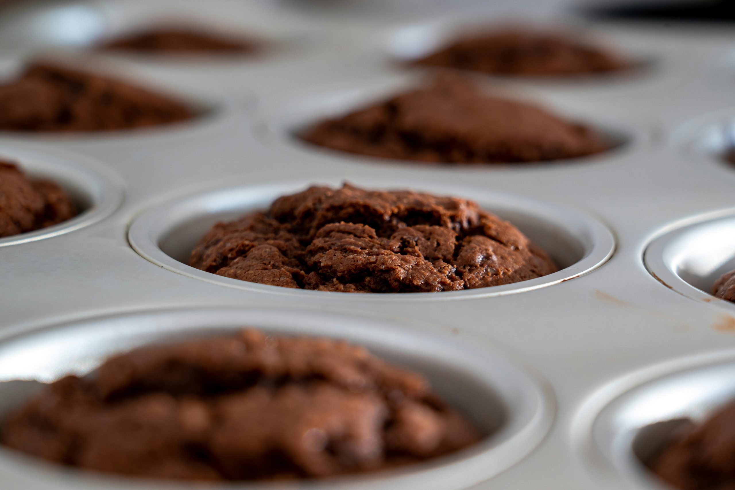 Close-up of freshly baked chocolate muffins cooling in a muffin pan. Perfect dessert or snack.